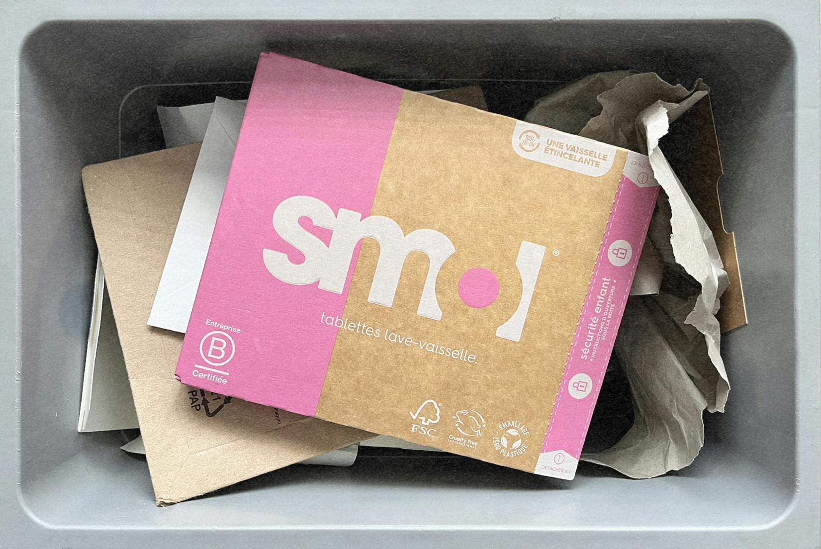 pack de tablettes pour lave-vaisselle smol dans un bac de recyclage pour cartons et papiers.