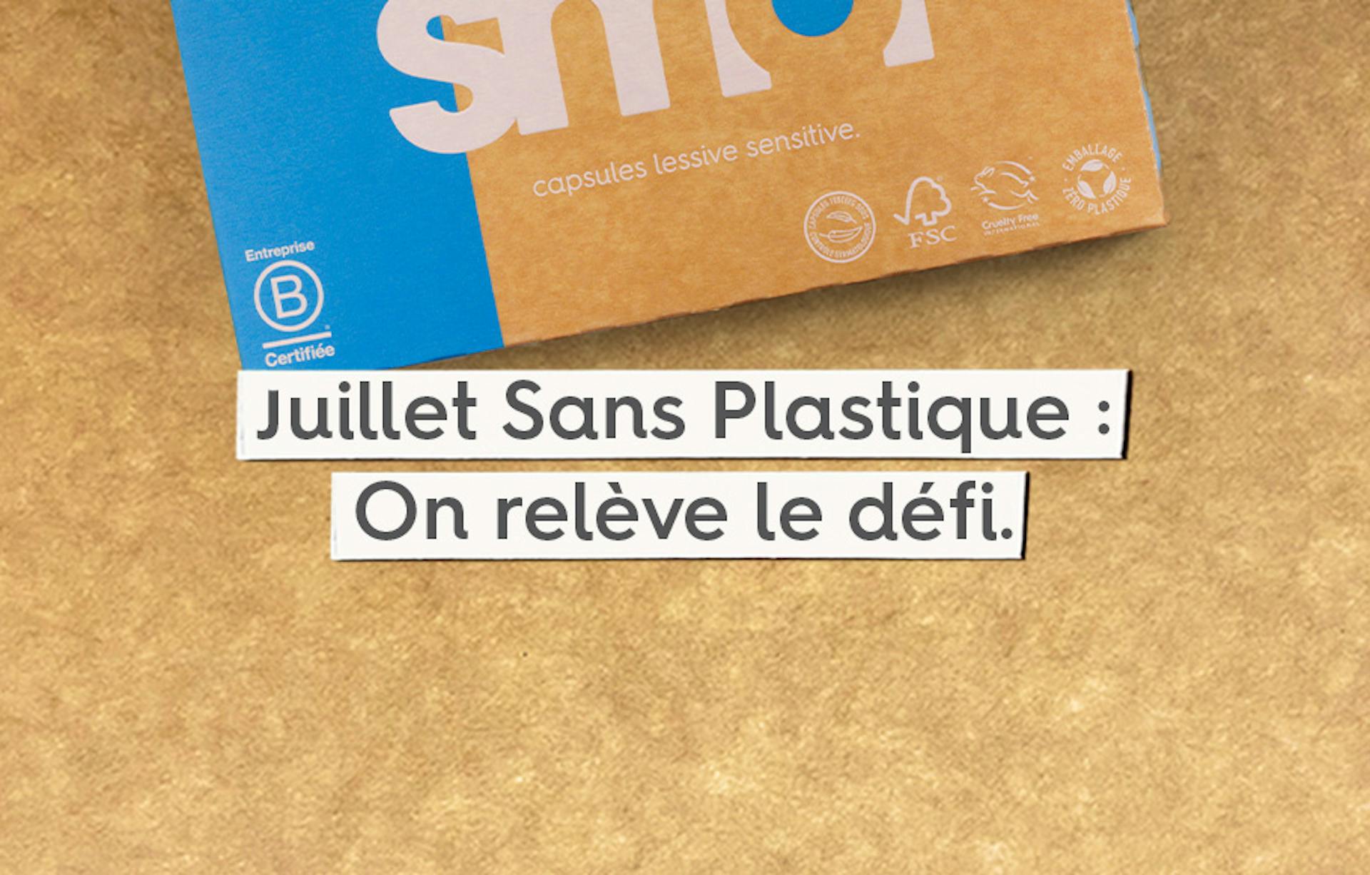 pack de capsules lessive active sur un fond en carton avec le texte « Juillet Sans Plastique : On relève le défi »