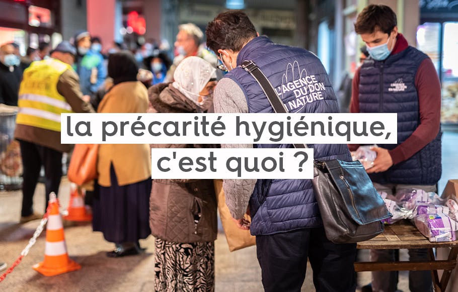 personnel de l'association caritative l'Agence du Don en Nature, donnant des produits hygiéniques dans la rue à des passants de nuit, avec le text « la précarité hygiénique, c'est quoi ? »