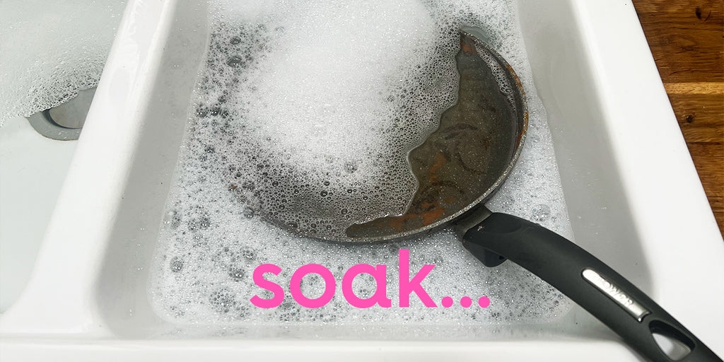 pan in a sink, soaked in soapy water. text: soak...