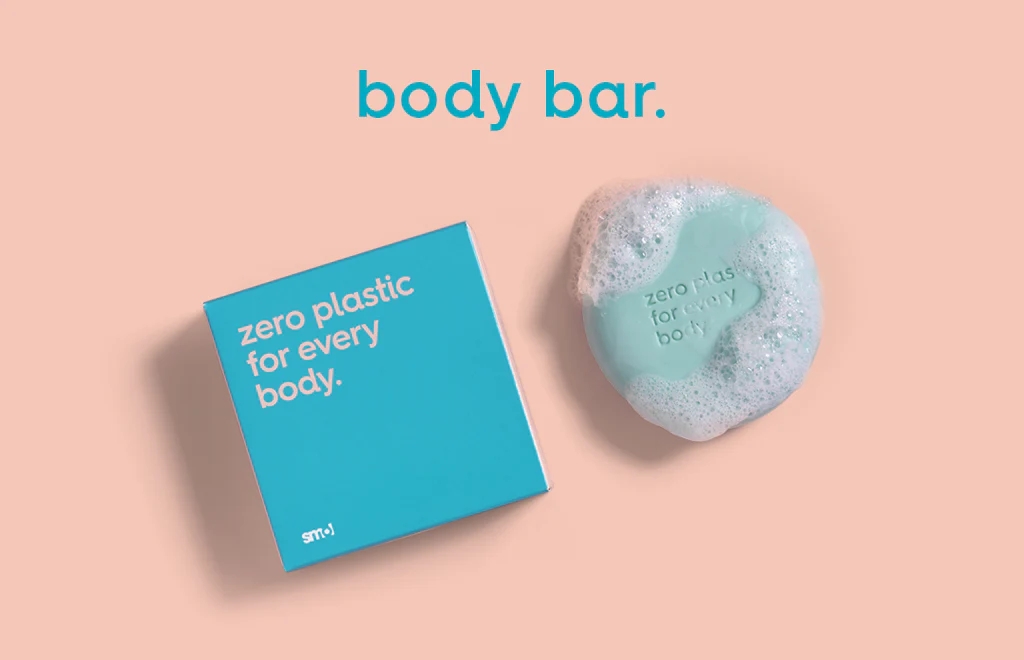 smol body bar with suds alongside its blue packaging