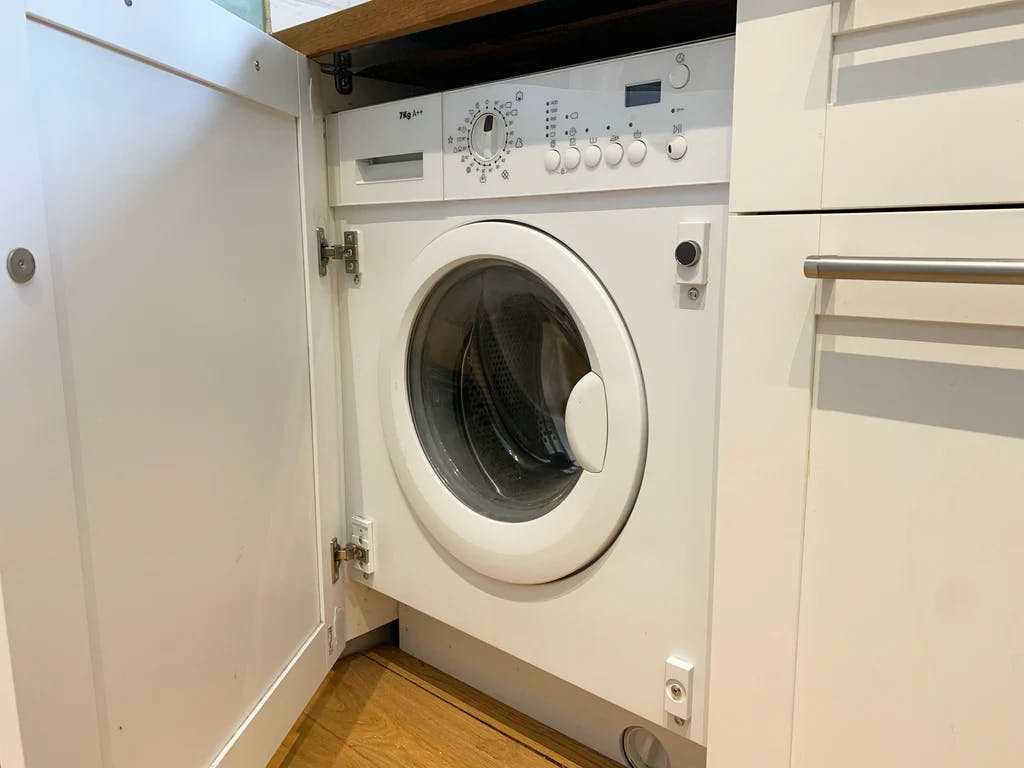 integrated washing machine with cupboard door open