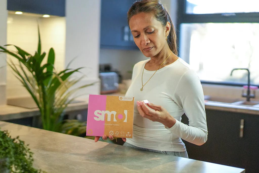 woman holding smol dishwasher tablets