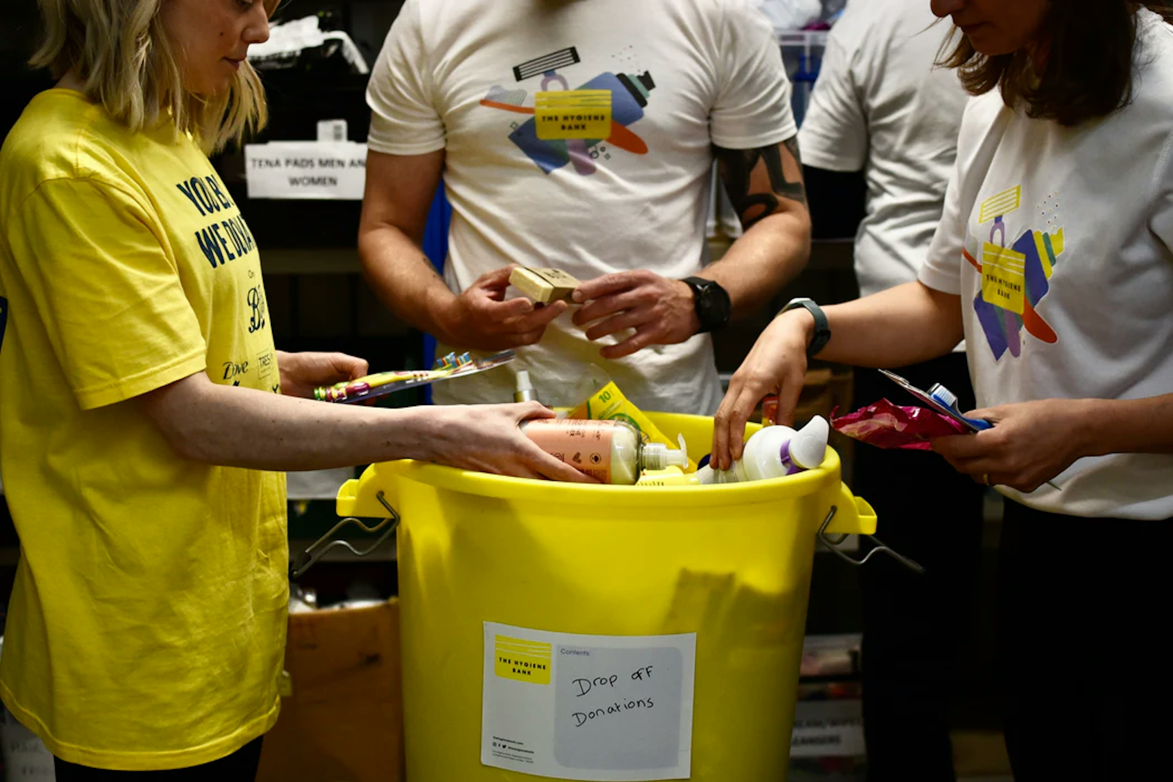 group of hygiene bank volunteers filling a bucked of donations