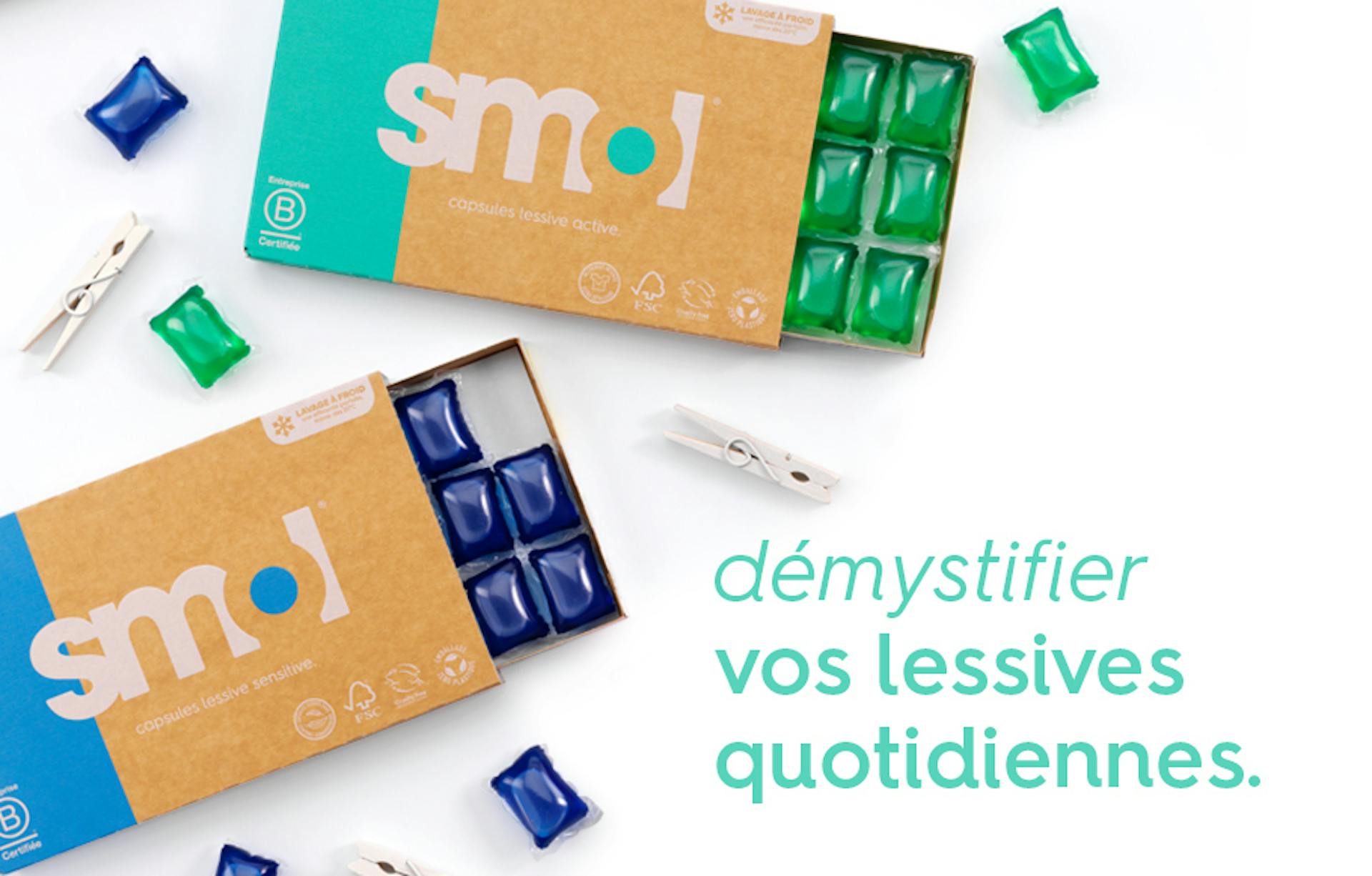 texte « démystifier vos lessives quotidiennes » sur une photo de packs de lessive active et sensitive smol, dont le tiroir est ouvert et révélant des capsules de lessive bleue et verte.