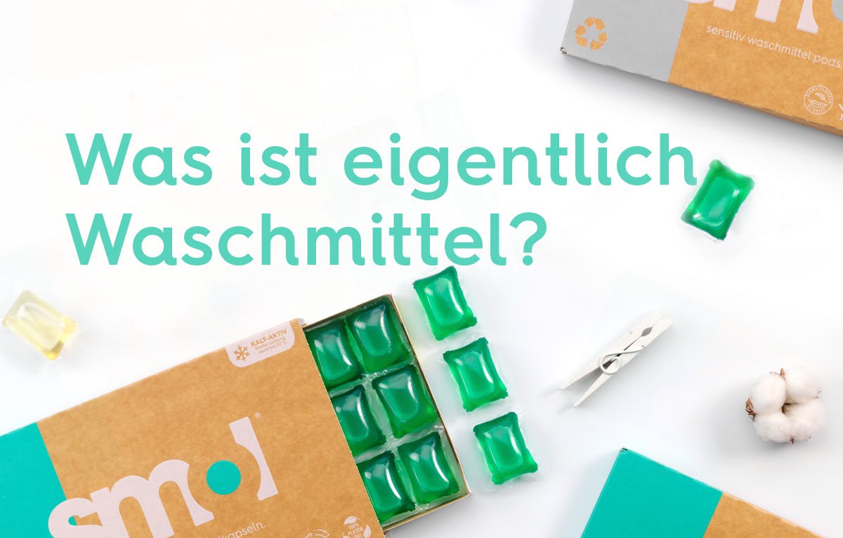 smol Universal Waschmittelkapsel Packung halb offen auf weißem Hintergrund, darauf der Text "Was st eigentlich Waschmittel"