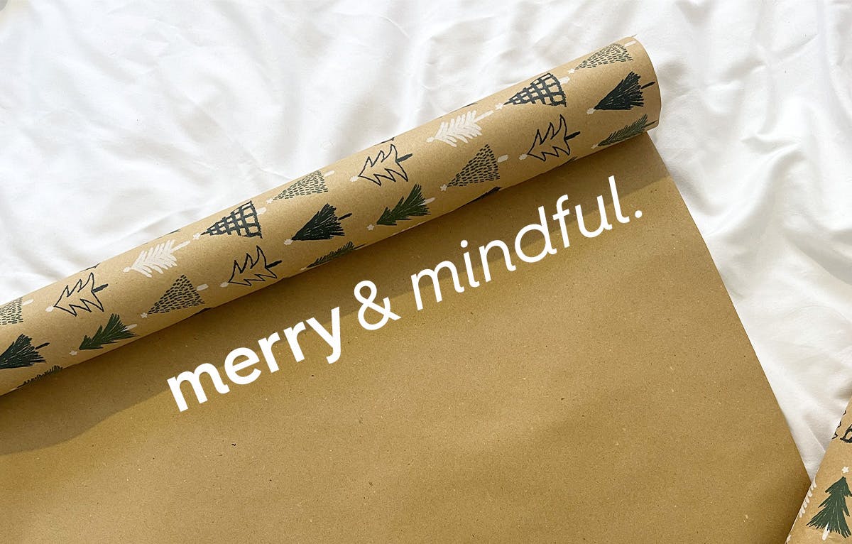 christmas wrapping paper rolled out. text: merry and mindful