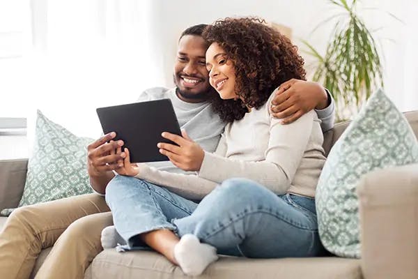 Couple on the couch with a tablet