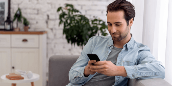 Man sat on sofa checking phone