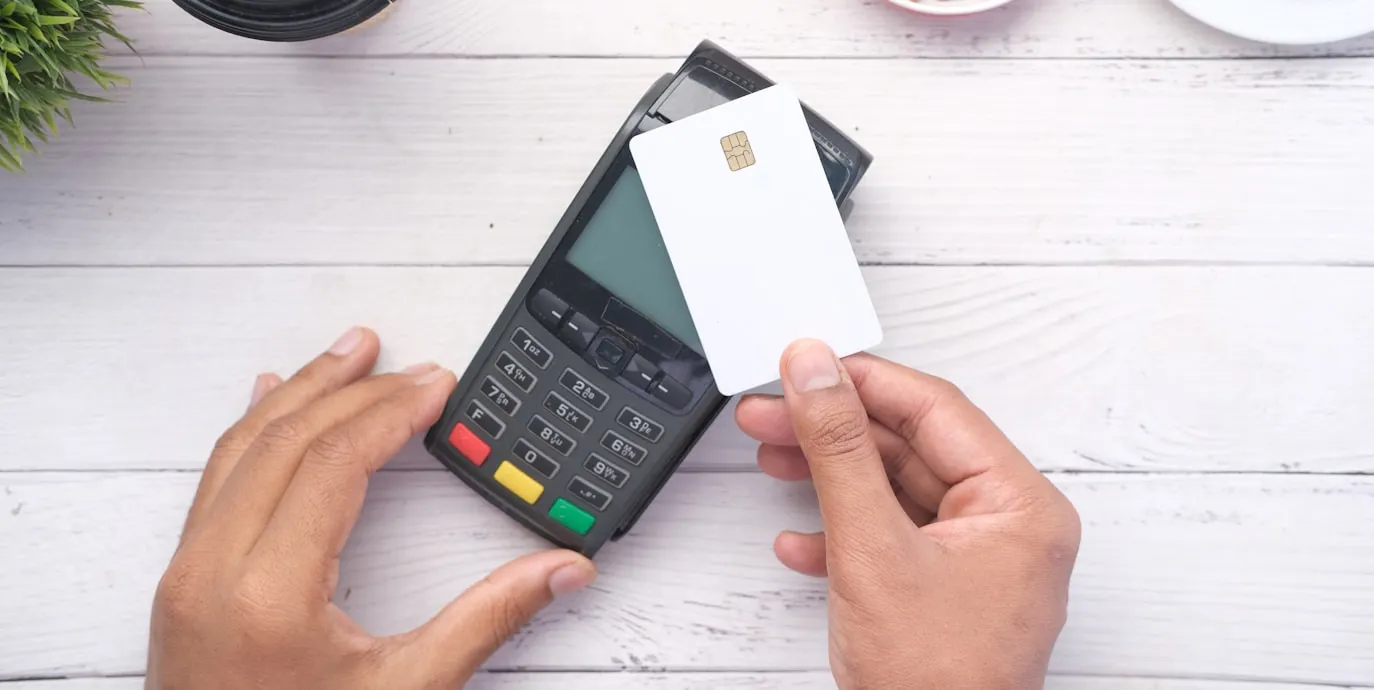 A person holding a credit card next to a calculator