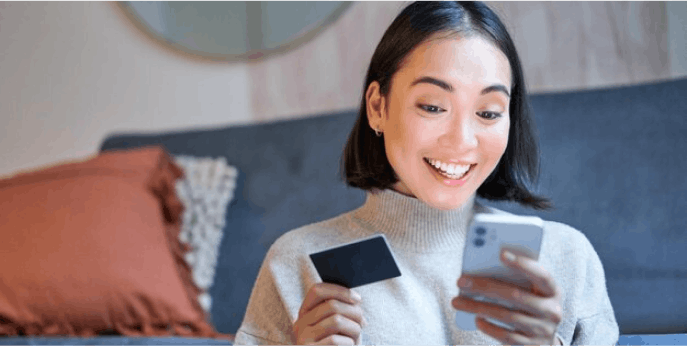 Women checking phone with credit card