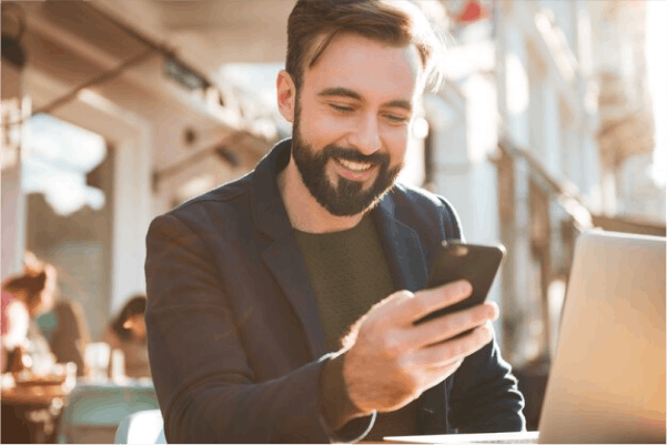 A man is looking at his phone in a restaurant
