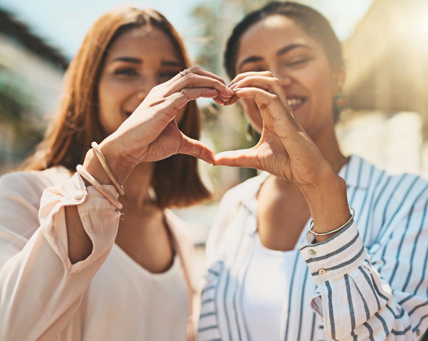 two people creating a heart with their hands
