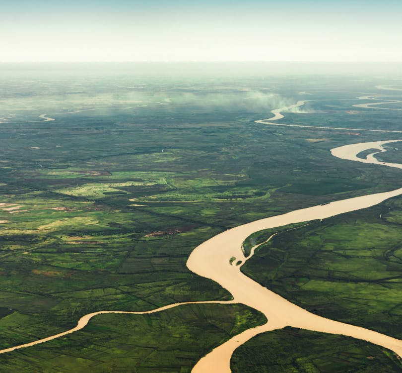 Photo of a winding river from aerial view with a lot of greenery around it