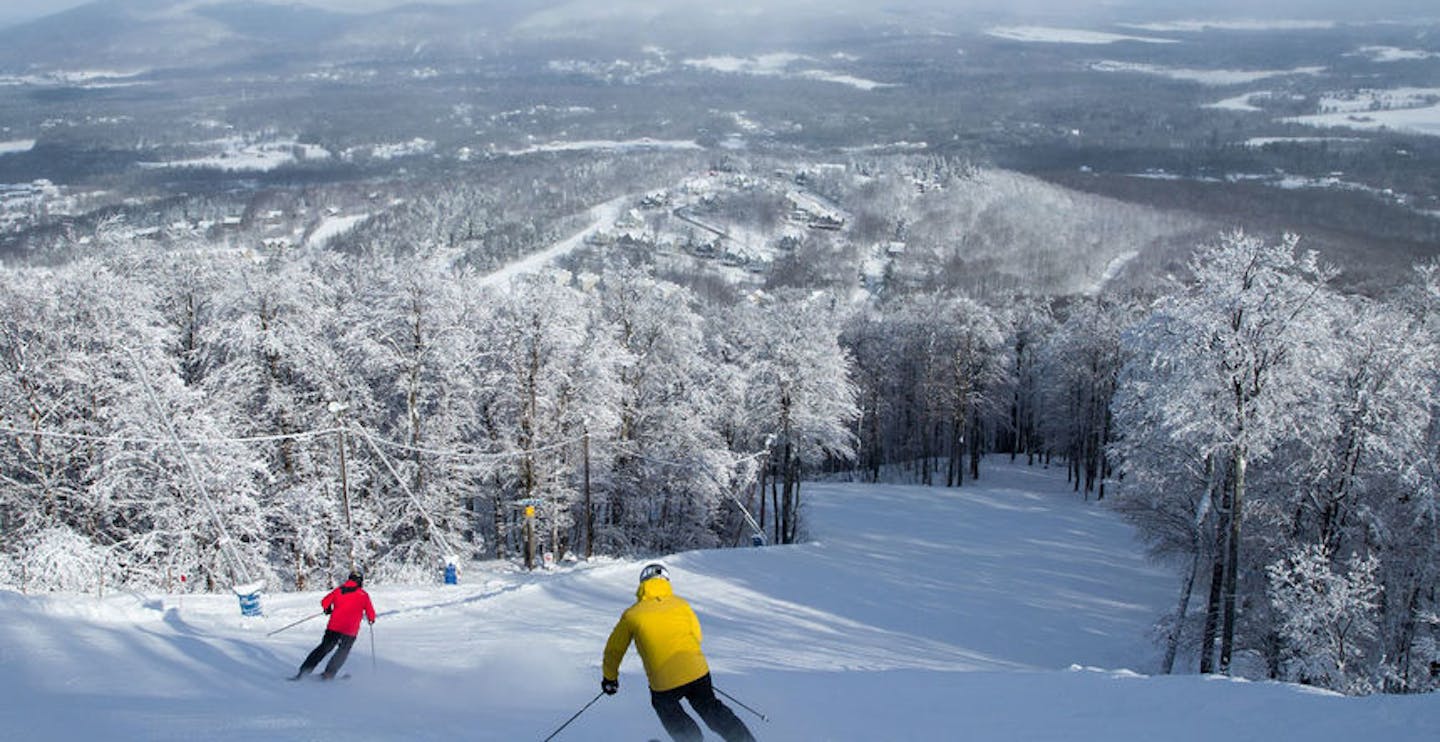 Two male skiers in colorful ski attire hitting the slopes at Ski Bromont in Quebec, Canada, near Montreal.