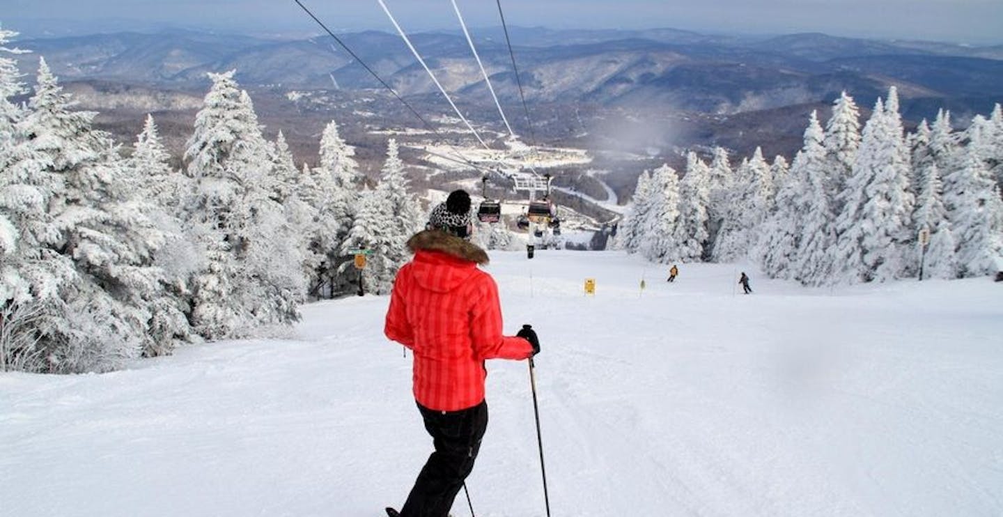 Skier of undiscernible gender enjoying the view of Killington Ski Resort from Pico Mountain on the East Coast of the United States.