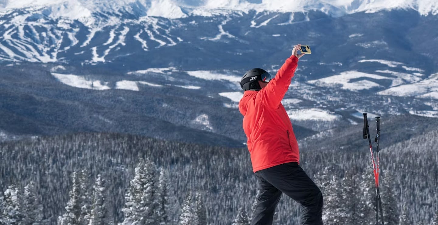 Male skier in red ski jacket taking a selfie on the slopes of Keystone in Colorado, USA.