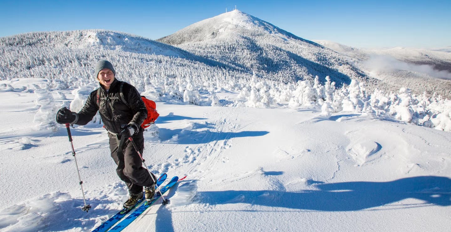 Male skier in black ski suit uphilling at Sugarloaf on the East Coast of the United States.