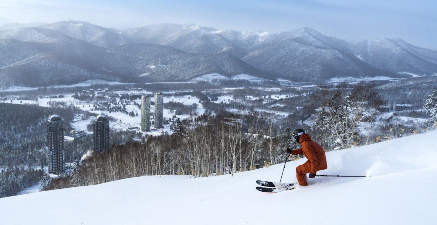 Skier of undiscernible gender in a ski suit with an extremely ugly tone of brown hitting the slopes at Tomamu Ski Resort in Hokkaido, Japan.