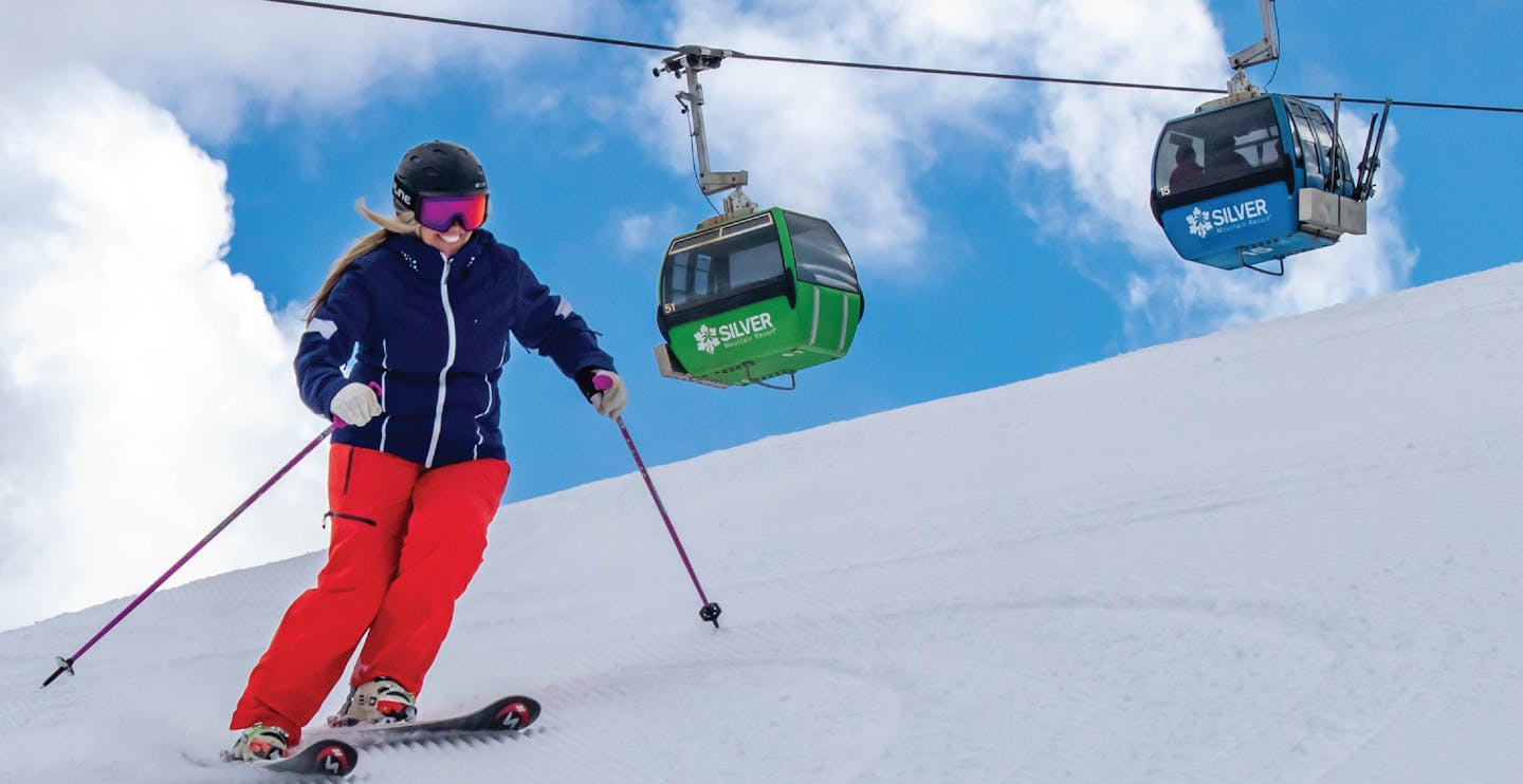 Female skier in red ski pants hitting the slopes at Silver Mountain in Idaho, USA.