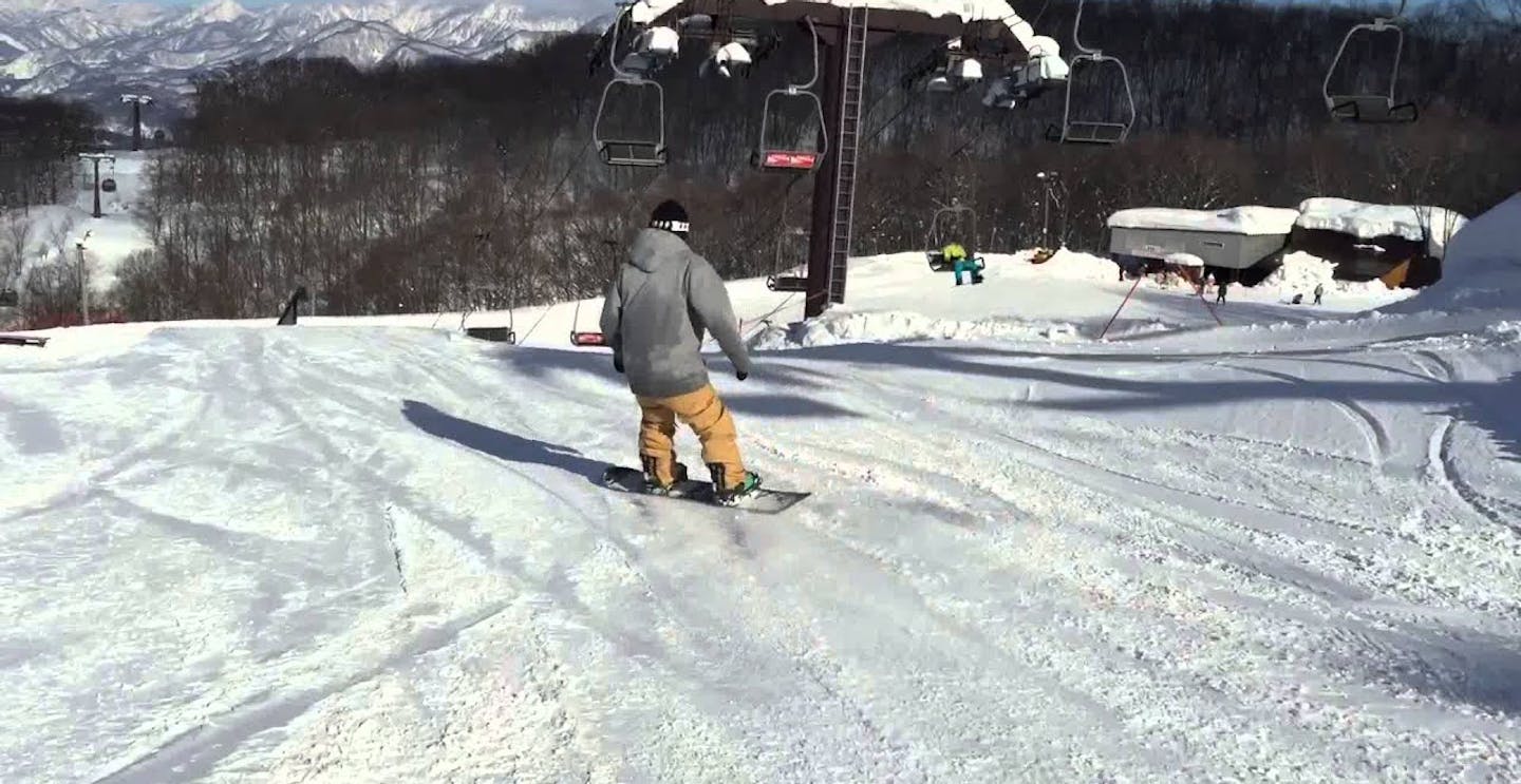 Male skier in yellow ski pants and grey ski jacket hitting the slopes at Hakuba 47 & Goryu in Japan.