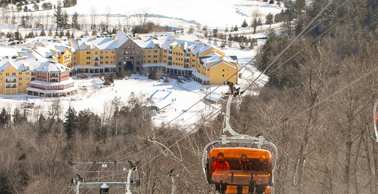 Covered chairlift taking skiers up the mountain at Okemo in Vermont, USA.