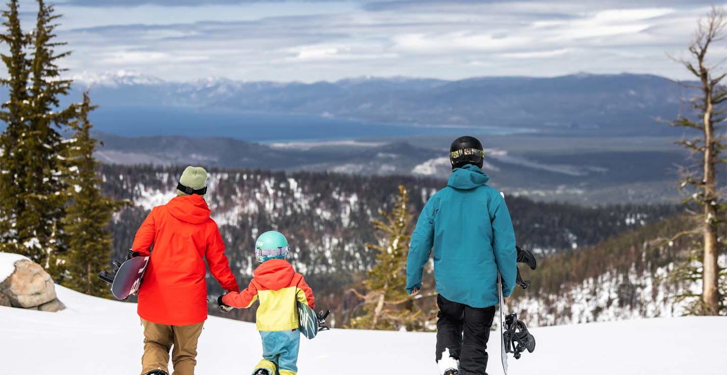 Family of snowboarders in colorful snowboarding attire descending the slopes at Sierra at Tahoe in California, USA.