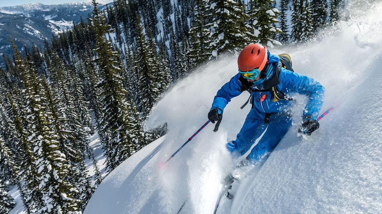 Skier of undiscernible gender in blue ski attire hitting the slopes at Blue Knob in Pennsylvania, USA.