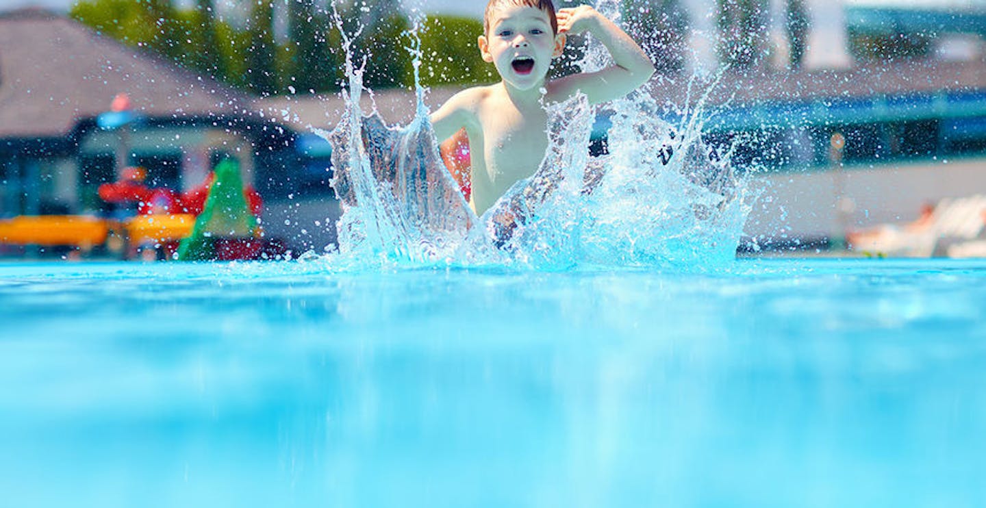 Happy boy jumping in the pool