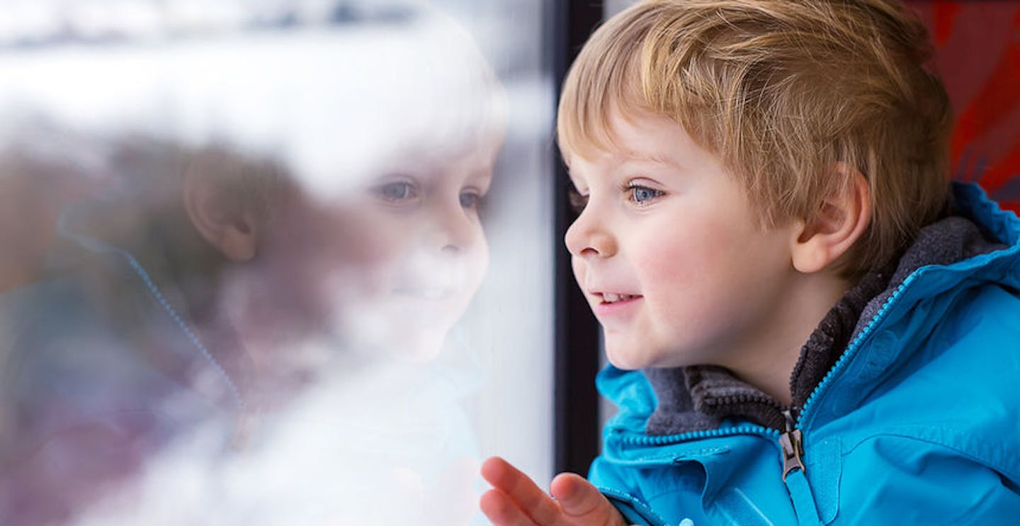 Toddler boy looking through window