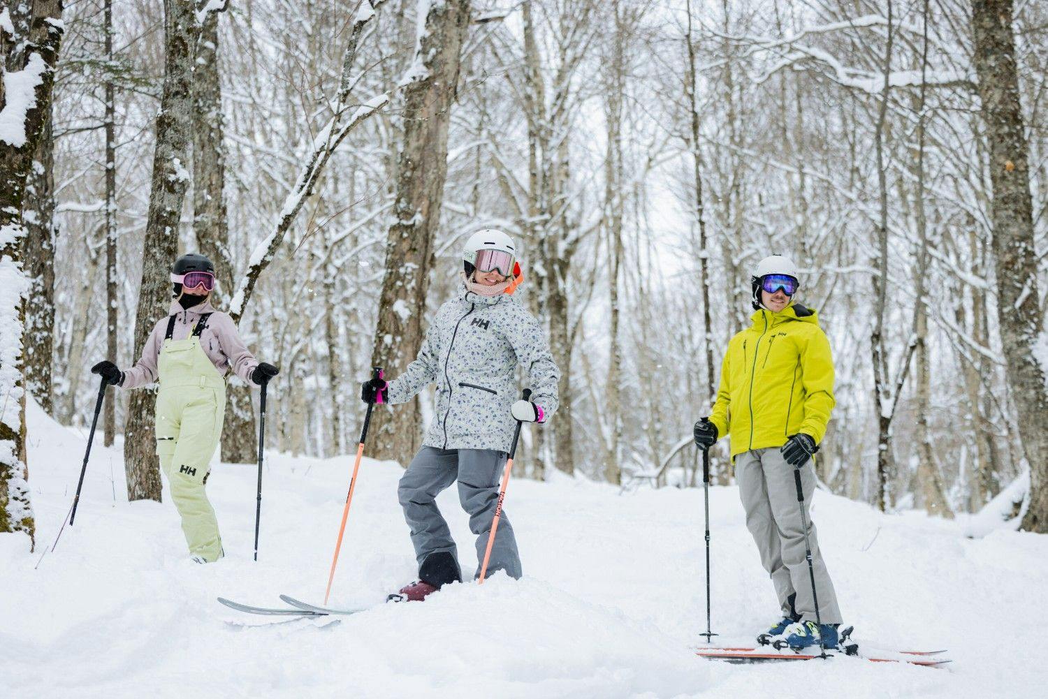 Three diverse adult skiers in colorful ski attire hitting the slopes at Stoneham Resort near Montreal in Quebec, Canada.