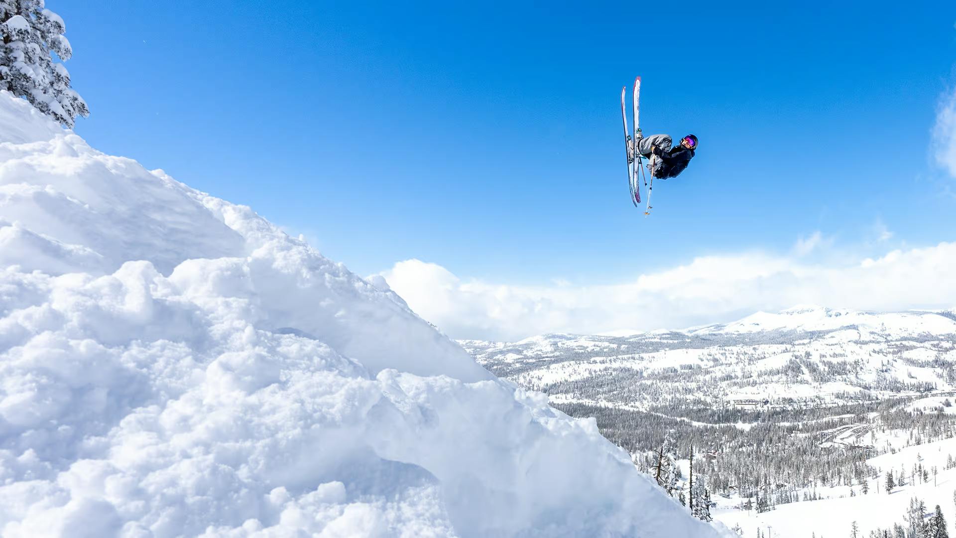 Skier of undiscernible gender in dark-colored ski attire hitting the slopes at Sugar Bowl Resort near Lake Tahoe in California, USA.
