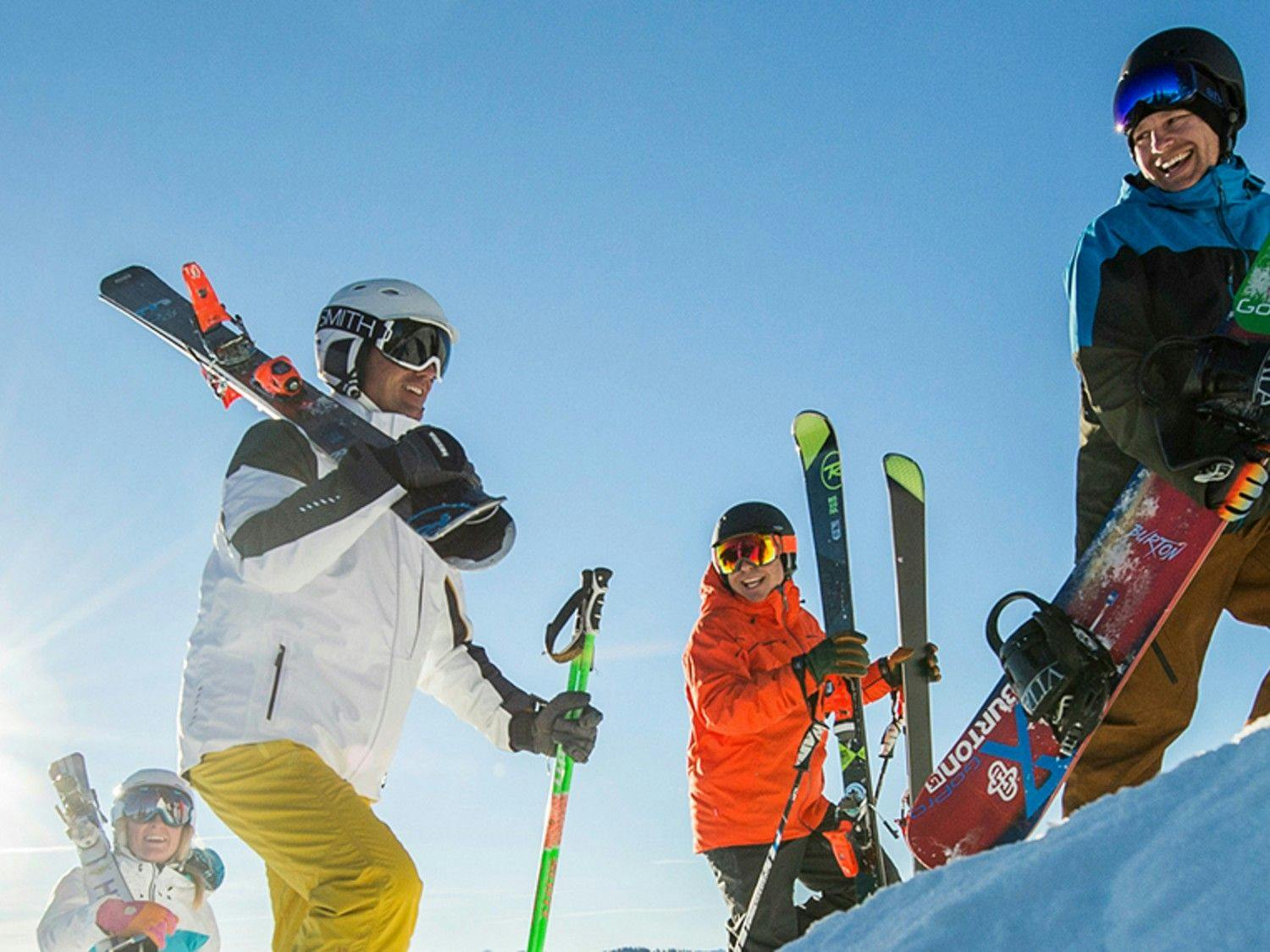 Four skiers in colorful ski attire uphilling at Park City in Utah, USA.