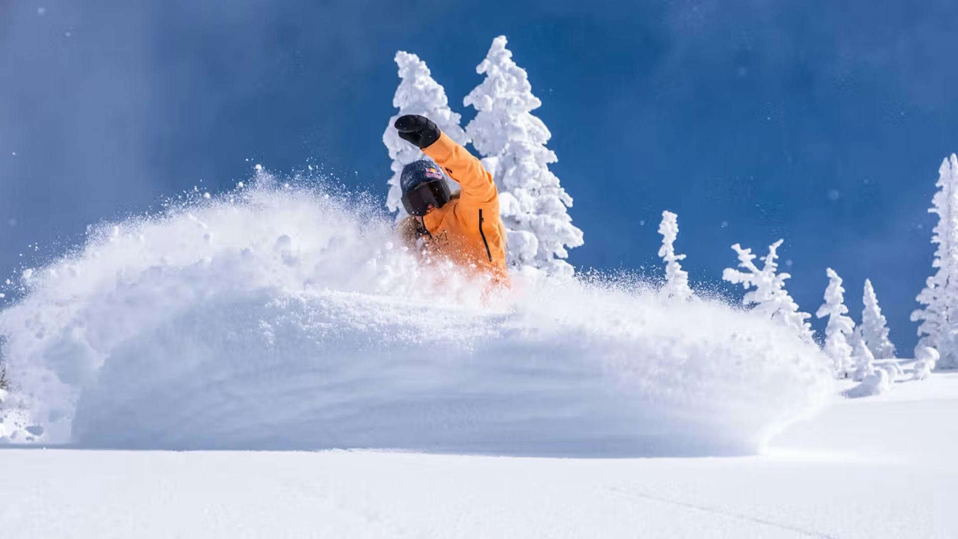 Skier of undiscernible gender in orange ski jacket hitting the slopes at Brighton Resort near Salt Lake City in Utah, USA.