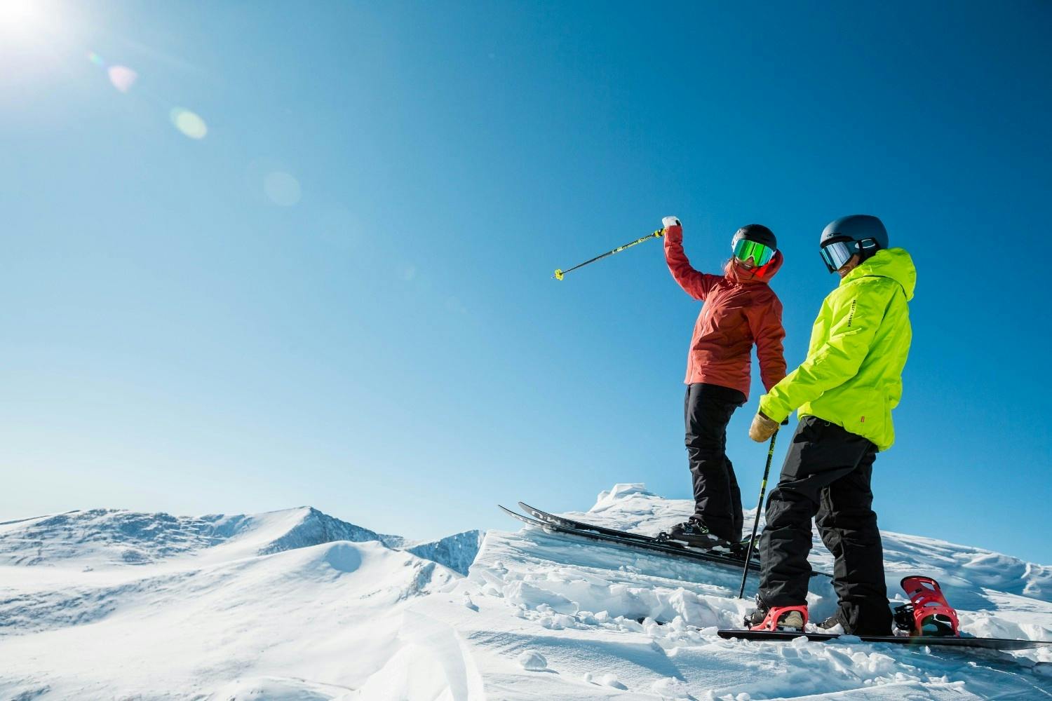 Two skiers of undiscernible gender in bright colorful ski attire hitting the slopes at Beaver Creek Resort in Colorado, USA.