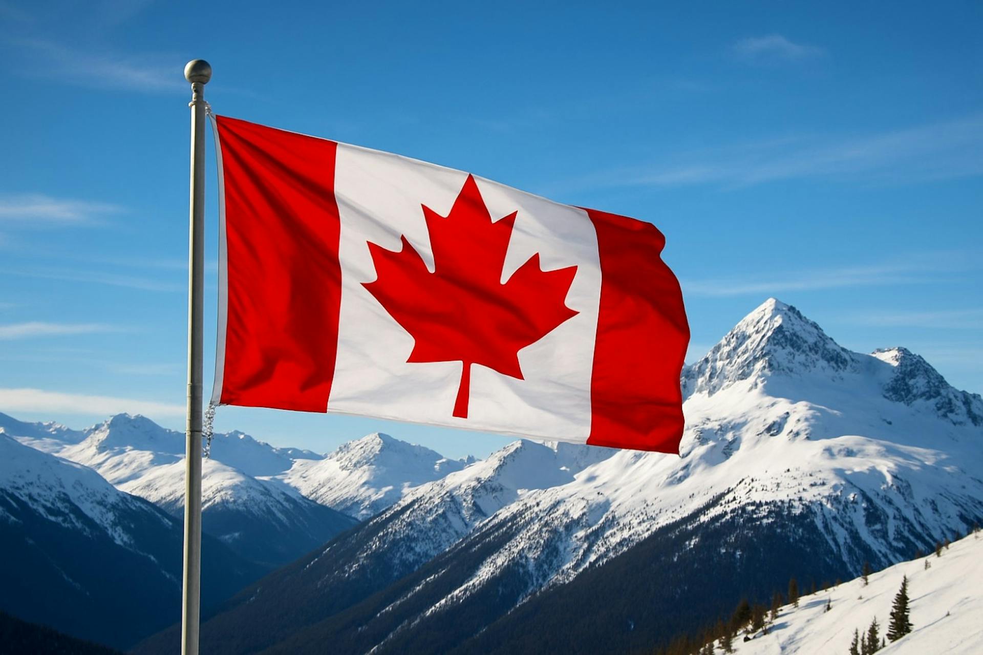 The Canadian flag waving proudly with the peaks of Whistler Blackcomb in the background.