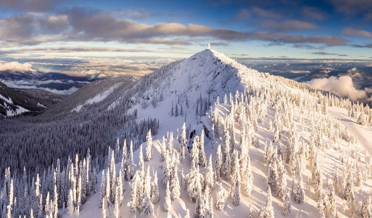 Aerial shot of the snowy peak at dawn at RED Mountain Resort in British Columbia, Canada.