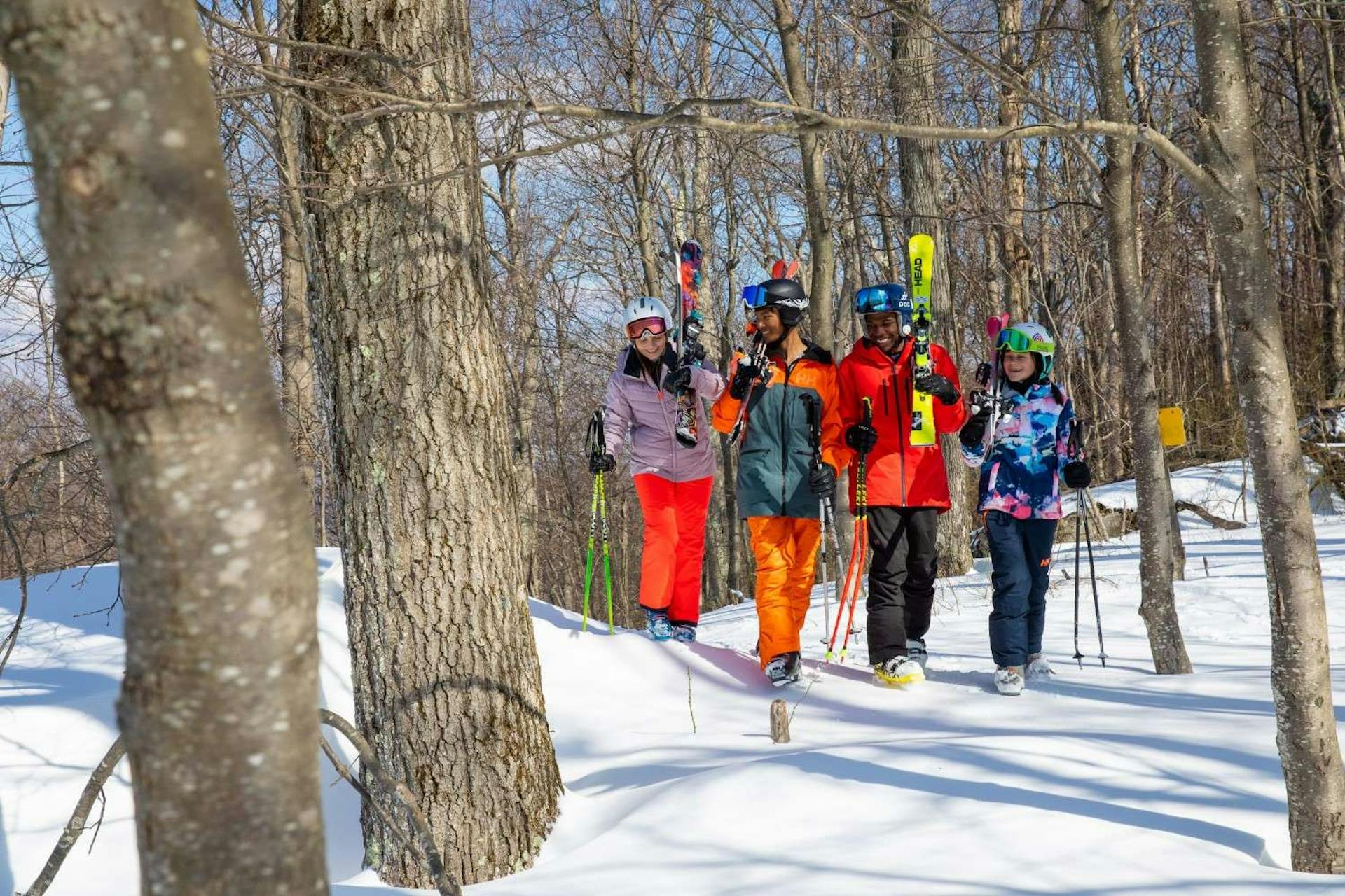 Diverse gang of four teenage skiers uphilling to their next spot at Wisp Resort near Washington, D.C., USA.