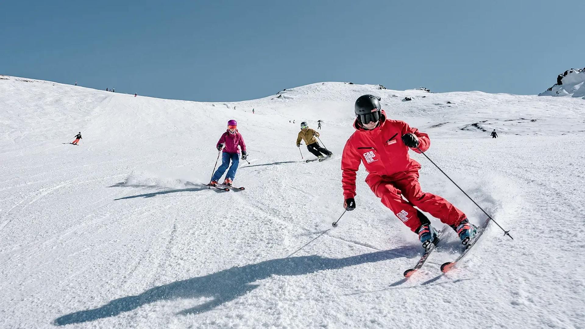 Three diverse skiers in brightly-colored ski attire hitting the slopes at Cardrona in New Zealand.