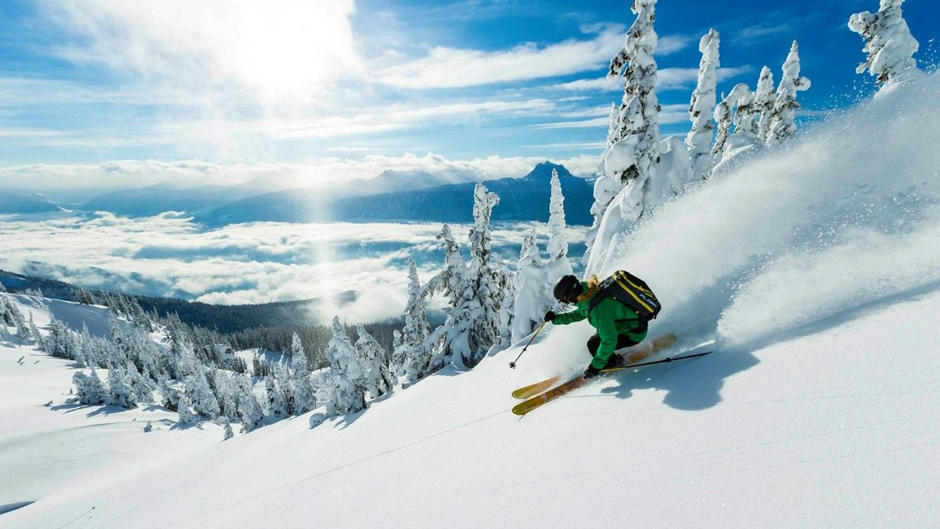 Skier of undiscernible gender in green ski attire hitting the slopes at Mount Hutt in New Zealand.