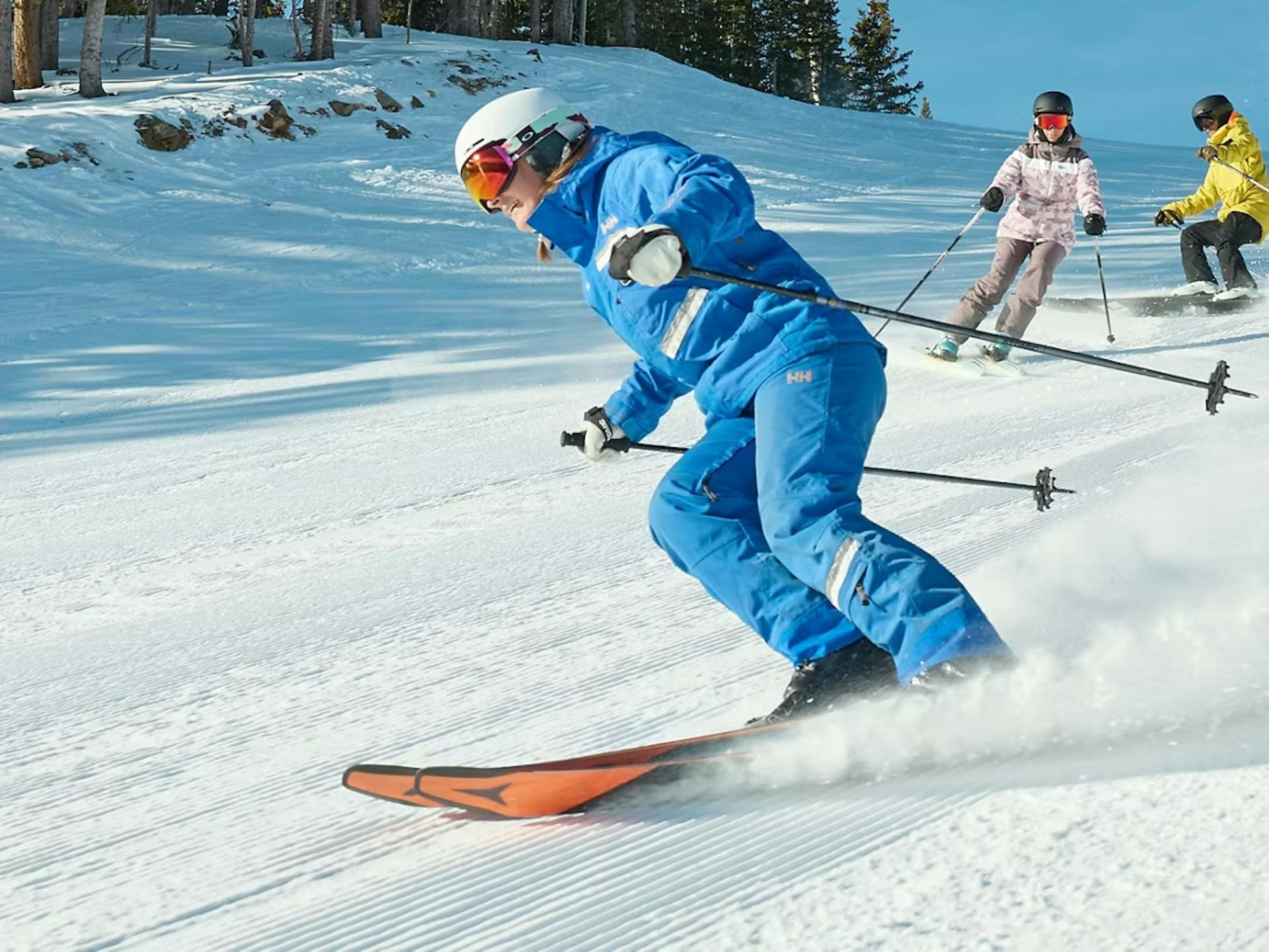 Three diverse skiers in colorful ski attire hitting the slopes at Breckenridge Ski Resort in Colorado, USA.