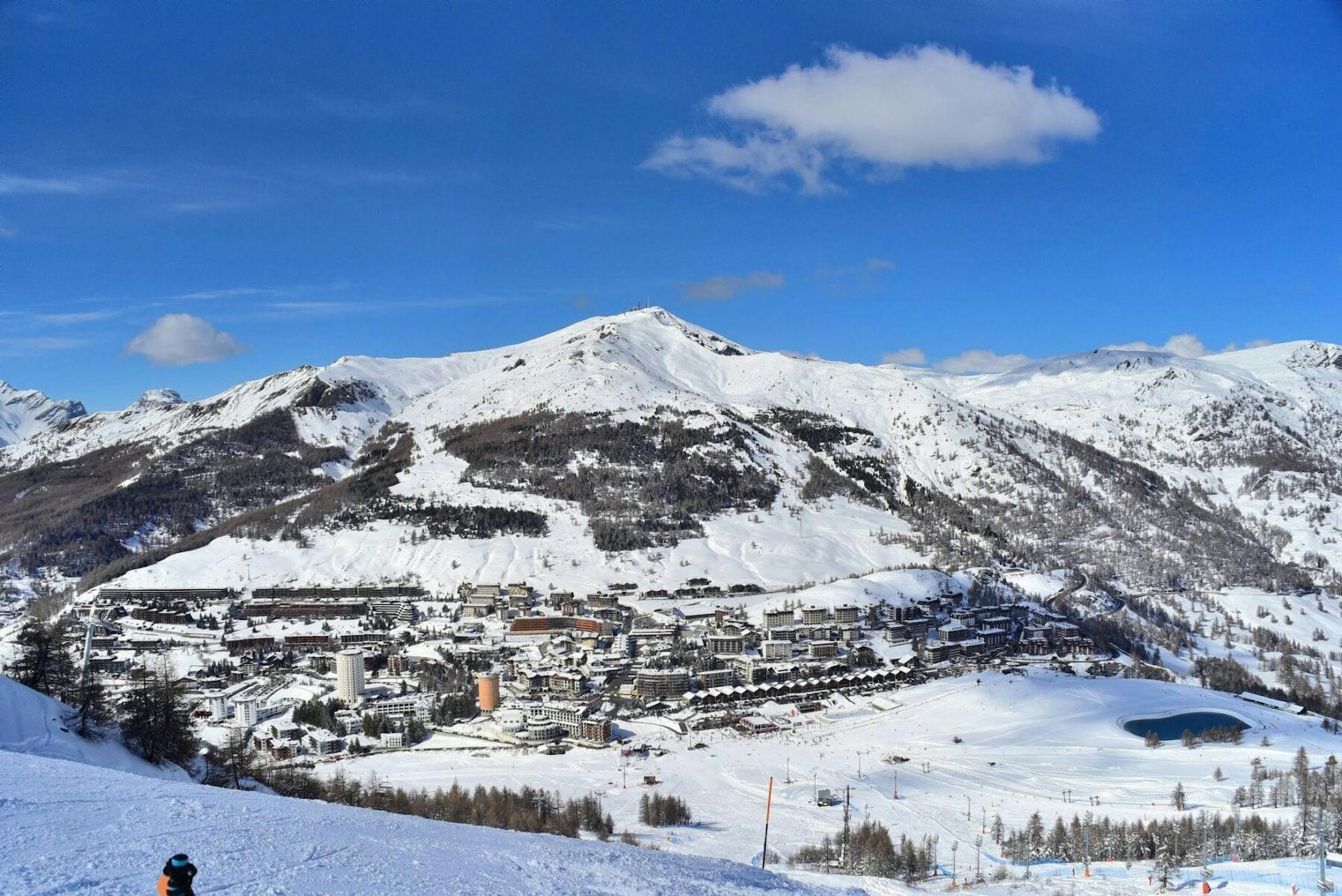 Sunny afternoon over the base village and slopes of Sestriere in Italy, Europe.