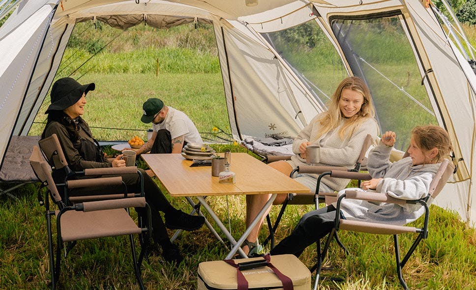 a photo of four people under a shelter smiling and having a conversation