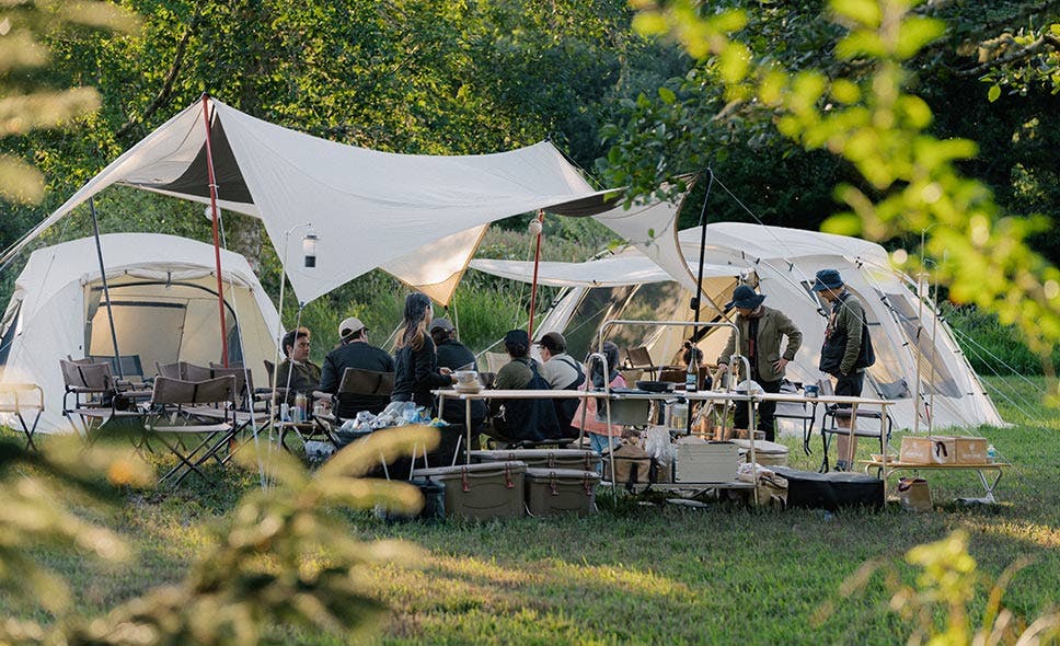 a photo of a group of people camping with a snow peak tarp and tents