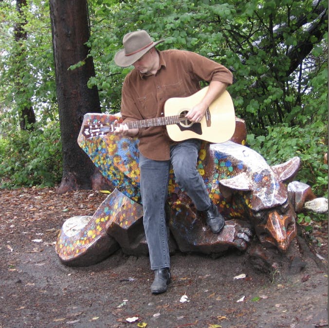 Joel Underwood with guitar in nature