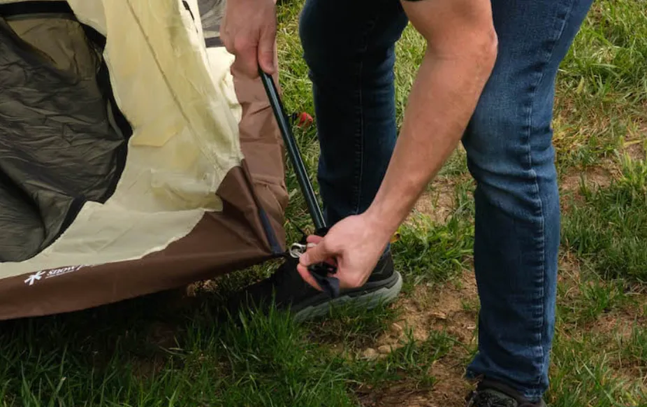 A male human setting up a tent