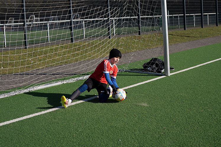 Torwart fängt den Ball am Boden während einer Trainingsübung – PWR PLY Soccer Academy


