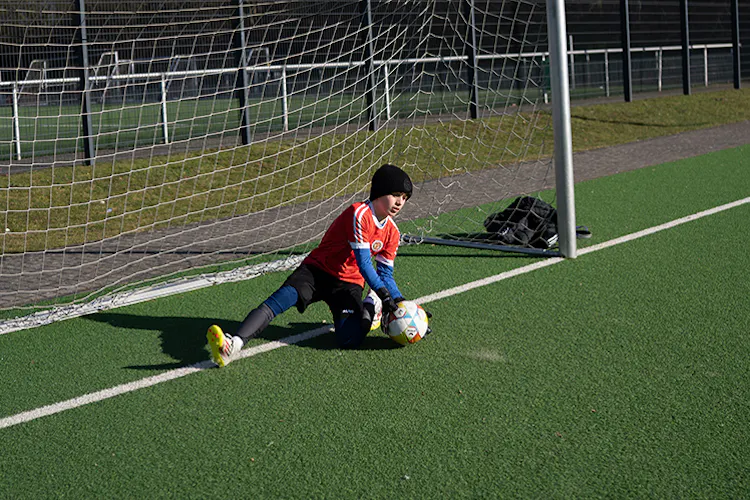 Torwart fängt den Ball am Boden während einer Trainingsübung – PWR PLY Soccer Academy