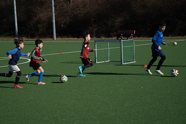 Trainingssituation mit Toren und Kindern im Spiel auf dem Fußballplatz – PWR PLY Soccer Academy
