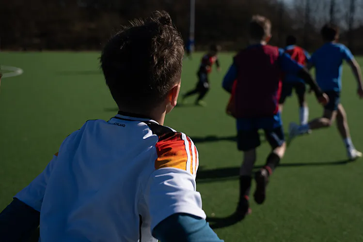 Perspektive aus dem Spielgeschehen mit laufenden Kindern im Training – PWR PLY Soccer Academy